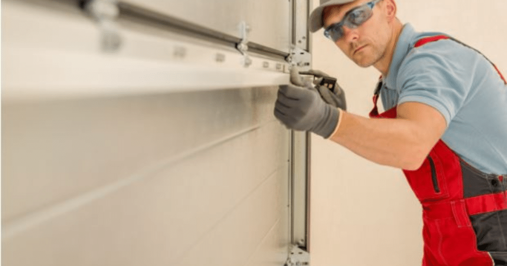 Technician fixing a metal garage door.