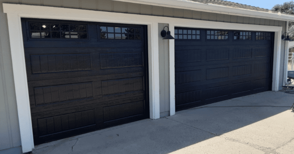 Double black garage doors with window panels.